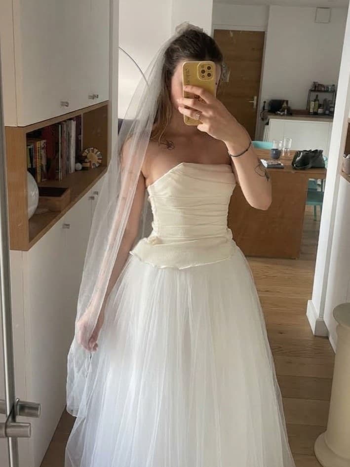 Un essayage devant le miroir de l'atelier, robe bustier et voile de tulle
